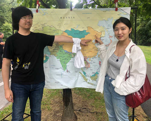 Posing with a map of China